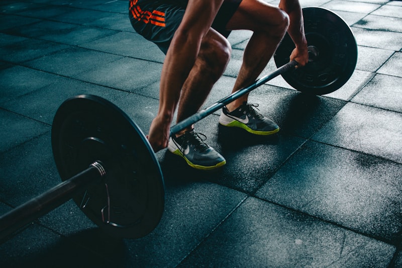 Person performing a dumbbell exercise in gym